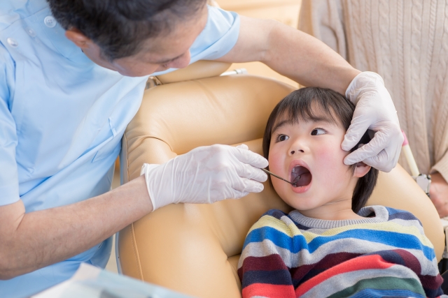 歯医者で治療を受ける子供